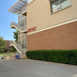 The outside of the Student Disability Resource Center which is a brown brick building with green hedges around it.