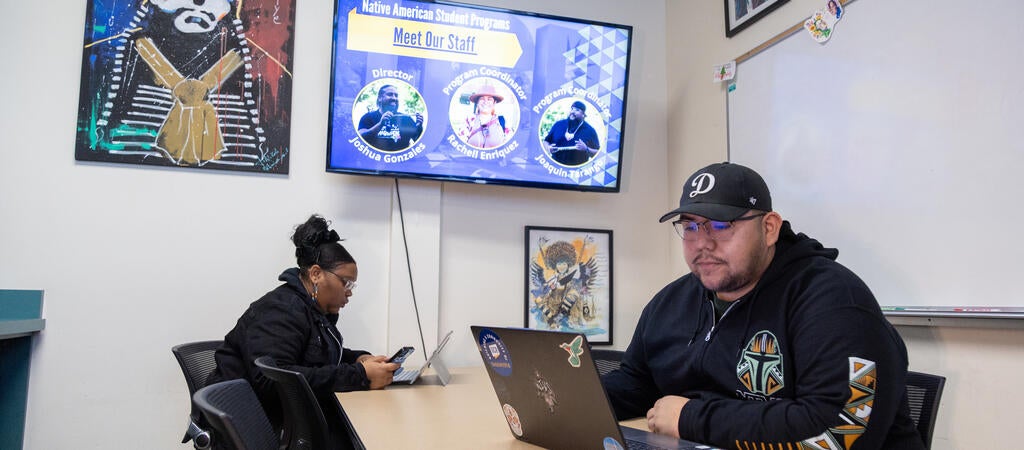 Two students sitting at a desk in the Native American Student Programs office.